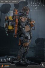 SAM (DELUXE VERSION) DEATH STRANDING 2: ON THE BEACH VIDEOGAME MASTERPIECE HOT TOYS 1/6. En Death Stranding 2: On the Beach, Sam Porter Bridges atraviesa la Australia postapocalíptica, reconstruyendo la Red Quiral y reconectando comunidades en medio de nuevas y duras amenazas. Hot Toys presenta con orgullo la figura coleccionable de Sam a escala 1/6 (versión Deluxe): una versión mejorada con numerosos accesorios y opciones de exhibición mejoradas. Al igual que la versión normal, esta figura de acción incluye una cabeza esculpida con ojos giratorios y cabello castaño oscuro cuidadosamente elaborado, un traje de puente levadizo con efecto reflectante luminiscente UV, un arnés utilitario de cuerpo entero, un esqueleto de batalla desmontable, armadura de espalda con escáner Odradek y botas de transporte, todo ello con un realismo desgastado. La versión Deluxe incluye un Bumerán de Sangre extra abierto, en homenaje al uso de la sangre de Sam en el juego. Incluye dos Pizzas de Goma, que hacen referencia a las técnicas favoritas de los fans de Pizza-Do. Además de las cargas medianas y grandes predeterminadas, también incluye un contenedor de carga extra dañado para más opciones de exhibición. La base de la figura del diorama APAS 4000 con iluminación LED completa el conjunto, permitiendo a los coleccionistas realzar su exhibición y recrear el enfrentamiento de Death Stranding 2.