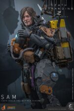 SAM DEATH STRANDING 2: ON THE BEACH VIDEOGAME MASTERPIECE HOT TOYS 1/6. En Death Stranding 2: On the Beach, el protagonista Sam Porter Bridges se embarca en una misión a través de la Australia postapocalíptica, trabajando para reconectar comunidades aisladas a través de la red Chiral en medio de nuevas amenazas ambientales y desafíos de combate. Hot Toys se complace en anunciar la figura coleccionable de Sam a escala 1/6, que captura fielmente la apariencia de Reedus en el juego. La figura de acción presenta una cabeza recién esculpida con ojos giratorios separados y un cabello castaño oscuro finamente detallado. Su traje de puente levadizo incorpora un efecto reflectante luminoso UV, complementado con un arnés utilitario de cuerpo completo, un esqueleto de batalla desmontable, armadura de espalda con escáner Odradek y botas de transporte, todo ello desgastado para un realismo auténtico y desgastado. Equipado con nueve manos enguantadas, Sam está listo para cualquier exhibición. Su arsenal incluye un Strand, una pistola ametralladora, un rifle de asalto LW Lv2 y un bumerán de sangre plegado que se puede acoplar a su arnés.