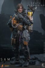 SAM DEATH STRANDING 2: ON THE BEACH VIDEOGAME MASTERPIECE HOT TOYS 1/6. En Death Stranding 2: On the Beach, el protagonista Sam Porter Bridges se embarca en una misión a través de la Australia postapocalíptica, trabajando para reconectar comunidades aisladas a través de la red Chiral en medio de nuevas amenazas ambientales y desafíos de combate. Hot Toys se complace en anunciar la figura coleccionable de Sam a escala 1/6, que captura fielmente la apariencia de Reedus en el juego. La figura de acción presenta una cabeza recién esculpida con ojos giratorios separados y un cabello castaño oscuro finamente detallado. Su traje de puente levadizo incorpora un efecto reflectante luminoso UV, complementado con un arnés utilitario de cuerpo completo, un esqueleto de batalla desmontable, armadura de espalda con escáner Odradek y botas de transporte, todo ello desgastado para un realismo auténtico y desgastado. Equipado con nueve manos enguantadas, Sam está listo para cualquier exhibición. Su arsenal incluye un Strand, una pistola ametralladora, un rifle de asalto LW Lv2 y un bumerán de sangre plegado que se puede acoplar a su arnés.