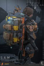 SAM DEATH STRANDING 2: ON THE BEACH VIDEOGAME MASTERPIECE HOT TOYS 1/6. En Death Stranding 2: On the Beach, el protagonista Sam Porter Bridges se embarca en una misión a través de la Australia postapocalíptica, trabajando para reconectar comunidades aisladas a través de la red Chiral en medio de nuevas amenazas ambientales y desafíos de combate. Hot Toys se complace en anunciar la figura coleccionable de Sam a escala 1/6, que captura fielmente la apariencia de Reedus en el juego. La figura de acción presenta una cabeza recién esculpida con ojos giratorios separados y un cabello castaño oscuro finamente detallado. Su traje de puente levadizo incorpora un efecto reflectante luminoso UV, complementado con un arnés utilitario de cuerpo completo, un esqueleto de batalla desmontable, armadura de espalda con escáner Odradek y botas de transporte, todo ello desgastado para un realismo auténtico y desgastado. Equipado con nueve manos enguantadas, Sam está listo para cualquier exhibición. Su arsenal incluye un Strand, una pistola ametralladora, un rifle de asalto LW Lv2 y un bumerán de sangre plegado que se puede acoplar a su arnés.