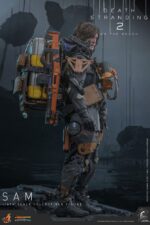 SAM DEATH STRANDING 2: ON THE BEACH VIDEOGAME MASTERPIECE HOT TOYS 1/6. En Death Stranding 2: On the Beach, el protagonista Sam Porter Bridges se embarca en una misión a través de la Australia postapocalíptica, trabajando para reconectar comunidades aisladas a través de la red Chiral en medio de nuevas amenazas ambientales y desafíos de combate. Hot Toys se complace en anunciar la figura coleccionable de Sam a escala 1/6, que captura fielmente la apariencia de Reedus en el juego. La figura de acción presenta una cabeza recién esculpida con ojos giratorios separados y un cabello castaño oscuro finamente detallado. Su traje de puente levadizo incorpora un efecto reflectante luminoso UV, complementado con un arnés utilitario de cuerpo completo, un esqueleto de batalla desmontable, armadura de espalda con escáner Odradek y botas de transporte, todo ello desgastado para un realismo auténtico y desgastado. Equipado con nueve manos enguantadas, Sam está listo para cualquier exhibición. Su arsenal incluye un Strand, una pistola ametralladora, un rifle de asalto LW Lv2 y un bumerán de sangre plegado que se puede acoplar a su arnés.
