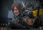 SAM DEATH STRANDING 2: ON THE BEACH VIDEOGAME MASTERPIECE HOT TOYS 1/6. En Death Stranding 2: On the Beach, el protagonista Sam Porter Bridges se embarca en una misión a través de la Australia postapocalíptica, trabajando para reconectar comunidades aisladas a través de la red Chiral en medio de nuevas amenazas ambientales y desafíos de combate. Hot Toys se complace en anunciar la figura coleccionable de Sam a escala 1/6, que captura fielmente la apariencia de Reedus en el juego. La figura de acción presenta una cabeza recién esculpida con ojos giratorios separados y un cabello castaño oscuro finamente detallado. Su traje de puente levadizo incorpora un efecto reflectante luminoso UV, complementado con un arnés utilitario de cuerpo completo, un esqueleto de batalla desmontable, armadura de espalda con escáner Odradek y botas de transporte, todo ello desgastado para un realismo auténtico y desgastado. Equipado con nueve manos enguantadas, Sam está listo para cualquier exhibición. Su arsenal incluye un Strand, una pistola ametralladora, un rifle de asalto LW Lv2 y un bumerán de sangre plegado que se puede acoplar a su arnés.