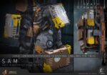 SAM DEATH STRANDING 2: ON THE BEACH VIDEOGAME MASTERPIECE HOT TOYS 1/6. En Death Stranding 2: On the Beach, el protagonista Sam Porter Bridges se embarca en una misión a través de la Australia postapocalíptica, trabajando para reconectar comunidades aisladas a través de la red Chiral en medio de nuevas amenazas ambientales y desafíos de combate. Hot Toys se complace en anunciar la figura coleccionable de Sam a escala 1/6, que captura fielmente la apariencia de Reedus en el juego. La figura de acción presenta una cabeza recién esculpida con ojos giratorios separados y un cabello castaño oscuro finamente detallado. Su traje de puente levadizo incorpora un efecto reflectante luminoso UV, complementado con un arnés utilitario de cuerpo completo, un esqueleto de batalla desmontable, armadura de espalda con escáner Odradek y botas de transporte, todo ello desgastado para un realismo auténtico y desgastado. Equipado con nueve manos enguantadas, Sam está listo para cualquier exhibición. Su arsenal incluye un Strand, una pistola ametralladora, un rifle de asalto LW Lv2 y un bumerán de sangre plegado que se puede acoplar a su arnés.