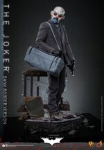 THE JOKER (BANK ROBBER VERSION) THE DARK KNIGHT HOT TOYS 1/6. El Joker de Heath Ledger conmocionó al mundo mucho antes de que se disparara la primera bala. Su risa escalofriante y sus acciones caóticas lo han convertido en un verdadero ícono del cine. La escena del robo al banco en Batman: El Caballero de la Noche sirve como una introducción cautivadora a la encantadora interpretación del Joker por parte de Ledger y define el tono del personaje. Hoy, Hot Toys se complace en presentar la figura coleccionable a escala 1/6 del Joker (versión ladrón de bancos), que ofrece una versión pulida y auténtica del icónico Joker del robo al banco de Ledger. Incluye dos cabezas detalladas con ojos giratorios separados, una con la siniestra sonrisa del Joker y otra con la máscara de payaso de ladrón de bancos. La figura captura la imagen del Joker del inolvidable atraco inicial al banco de El Caballero de la Noche. La figura incluye cabello verde oscuro de longitud media y texturas de piel finamente pintadas, incluyendo arrugas y manchas de maquillaje que recuerdan a la película. El atuendo de ladrón de bancos está meticulosamente confeccionado, con una camisa a rayas bajo un blazer y pantalones grises.