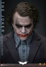 THE JOKER (BANK ROBBER VERSION) THE DARK KNIGHT HOT TOYS 1/6. El Joker de Heath Ledger conmocionó al mundo mucho antes de que se disparara la primera bala. Su risa escalofriante y sus acciones caóticas lo han convertido en un verdadero ícono del cine. La escena del robo al banco en Batman: El Caballero de la Noche sirve como una introducción cautivadora a la encantadora interpretación del Joker por parte de Ledger y define el tono del personaje. Hoy, Hot Toys se complace en presentar la figura coleccionable a escala 1/6 del Joker (versión ladrón de bancos), que ofrece una versión pulida y auténtica del icónico Joker del robo al banco de Ledger. Incluye dos cabezas detalladas con ojos giratorios separados, una con la siniestra sonrisa del Joker y otra con la máscara de payaso de ladrón de bancos. La figura captura la imagen del Joker del inolvidable atraco inicial al banco de El Caballero de la Noche. La figura incluye cabello verde oscuro de longitud media y texturas de piel finamente pintadas, incluyendo arrugas y manchas de maquillaje que recuerdan a la película. El atuendo de ladrón de bancos está meticulosamente confeccionado, con una camisa a rayas bajo un blazer y pantalones grises.