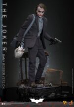 THE JOKER (BANK ROBBER VERSION) THE DARK KNIGHT HOT TOYS 1/6. El Joker de Heath Ledger conmocionó al mundo mucho antes de que se disparara la primera bala. Su risa escalofriante y sus acciones caóticas lo han convertido en un verdadero ícono del cine. La escena del robo al banco en Batman: El Caballero de la Noche sirve como una introducción cautivadora a la encantadora interpretación del Joker por parte de Ledger y define el tono del personaje. Hoy, Hot Toys se complace en presentar la figura coleccionable a escala 1/6 del Joker (versión ladrón de bancos), que ofrece una versión pulida y auténtica del icónico Joker del robo al banco de Ledger. Incluye dos cabezas detalladas con ojos giratorios separados, una con la siniestra sonrisa del Joker y otra con la máscara de payaso de ladrón de bancos. La figura captura la imagen del Joker del inolvidable atraco inicial al banco de El Caballero de la Noche. La figura incluye cabello verde oscuro de longitud media y texturas de piel finamente pintadas, incluyendo arrugas y manchas de maquillaje que recuerdan a la película. El atuendo de ladrón de bancos está meticulosamente confeccionado, con una camisa a rayas bajo un blazer y pantalones grises.