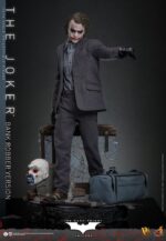 THE JOKER (BANK ROBBER VERSION) THE DARK KNIGHT HOT TOYS 1/6. El Joker de Heath Ledger conmocionó al mundo mucho antes de que se disparara la primera bala. Su risa escalofriante y sus acciones caóticas lo han convertido en un verdadero ícono del cine. La escena del robo al banco en Batman: El Caballero de la Noche sirve como una introducción cautivadora a la encantadora interpretación del Joker por parte de Ledger y define el tono del personaje. Hoy, Hot Toys se complace en presentar la figura coleccionable a escala 1/6 del Joker (versión ladrón de bancos), que ofrece una versión pulida y auténtica del icónico Joker del robo al banco de Ledger. Incluye dos cabezas detalladas con ojos giratorios separados, una con la siniestra sonrisa del Joker y otra con la máscara de payaso de ladrón de bancos. La figura captura la imagen del Joker del inolvidable atraco inicial al banco de El Caballero de la Noche. La figura incluye cabello verde oscuro de longitud media y texturas de piel finamente pintadas, incluyendo arrugas y manchas de maquillaje que recuerdan a la película. El atuendo de ladrón de bancos está meticulosamente confeccionado, con una camisa a rayas bajo un blazer y pantalones grises.