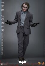 THE JOKER (BANK ROBBER VERSION) THE DARK KNIGHT HOT TOYS 1/6. El Joker de Heath Ledger conmocionó al mundo mucho antes de que se disparara la primera bala. Su risa escalofriante y sus acciones caóticas lo han convertido en un verdadero ícono del cine. La escena del robo al banco en Batman: El Caballero de la Noche sirve como una introducción cautivadora a la encantadora interpretación del Joker por parte de Ledger y define el tono del personaje. Hoy, Hot Toys se complace en presentar la figura coleccionable a escala 1/6 del Joker (versión ladrón de bancos), que ofrece una versión pulida y auténtica del icónico Joker del robo al banco de Ledger. Incluye dos cabezas detalladas con ojos giratorios separados, una con la siniestra sonrisa del Joker y otra con la máscara de payaso de ladrón de bancos. La figura captura la imagen del Joker del inolvidable atraco inicial al banco de El Caballero de la Noche. La figura incluye cabello verde oscuro de longitud media y texturas de piel finamente pintadas, incluyendo arrugas y manchas de maquillaje que recuerdan a la película. El atuendo de ladrón de bancos está meticulosamente confeccionado, con una camisa a rayas bajo un blazer y pantalones grises.