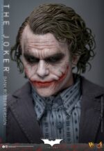 THE JOKER (BANK ROBBER VERSION) THE DARK KNIGHT HOT TOYS 1/6. El Joker de Heath Ledger conmocionó al mundo mucho antes de que se disparara la primera bala. Su risa escalofriante y sus acciones caóticas lo han convertido en un verdadero ícono del cine. La escena del robo al banco en Batman: El Caballero de la Noche sirve como una introducción cautivadora a la encantadora interpretación del Joker por parte de Ledger y define el tono del personaje. Hoy, Hot Toys se complace en presentar la figura coleccionable a escala 1/6 del Joker (versión ladrón de bancos), que ofrece una versión pulida y auténtica del icónico Joker del robo al banco de Ledger. Incluye dos cabezas detalladas con ojos giratorios separados, una con la siniestra sonrisa del Joker y otra con la máscara de payaso de ladrón de bancos. La figura captura la imagen del Joker del inolvidable atraco inicial al banco de El Caballero de la Noche. La figura incluye cabello verde oscuro de longitud media y texturas de piel finamente pintadas, incluyendo arrugas y manchas de maquillaje que recuerdan a la película. El atuendo de ladrón de bancos está meticulosamente confeccionado, con una camisa a rayas bajo un blazer y pantalones grises.