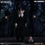 WEDNESDAY LIVING DEAD DOLLS MEZCO. Mezco Toyz vuelve a presentar dentro de su línea Living Dead Dolls la muñeca de Wednesday Addams, inspirada en la serie de Netflix "Wednesday" ("Miércoles" en España). La figura mide aproximadamente 25 cm de altura, cuenta con 5 puntos de articulación y se muestra con su característico vestido negro con cuello, mallas oscuras y botas. Luce su peinado clásico con coletas y un nuevo esculpido facial. Como accesorio se incluye su inseparable mano sirviente Cosa en pose estática. Se presenta en una caja con ventana.