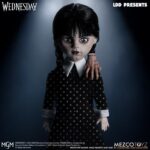 WEDNESDAY LIVING DEAD DOLLS MEZCO. Mezco Toyz vuelve a presentar dentro de su línea Living Dead Dolls la muñeca de Wednesday Addams, inspirada en la serie de Netflix "Wednesday" ("Miércoles" en España). La figura mide aproximadamente 25 cm de altura, cuenta con 5 puntos de articulación y se muestra con su característico vestido negro con cuello, mallas oscuras y botas. Luce su peinado clásico con coletas y un nuevo esculpido facial. Como accesorio se incluye su inseparable mano sirviente Cosa en pose estática. Se presenta en una caja con ventana.