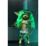 ULTIMATE GRETA GREMLINS 2: THE NEW BATCH. Neca vuelve a presentar la figura Ultimate de Greta, el único Gremlin femenino de la película "Gremlins 2: The New Batch" ("Gremlins 2: La nueva generación" en España). Mide 15 cm e incluye cabello sintético, 1x boa de plumas rosa, 1x poción hormonal y 2x manos intercambiables. Se entrega en una caja con ventana y solapa de apertura.