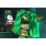 ULTIMATE GRETA GREMLINS 2: THE NEW BATCH. Neca vuelve a presentar la figura Ultimate de Greta, el único Gremlin femenino de la película "Gremlins 2: The New Batch" ("Gremlins 2: La nueva generación" en España). Mide 15 cm e incluye cabello sintético, 1x boa de plumas rosa, 1x poción hormonal y 2x manos intercambiables. Se entrega en una caja con ventana y solapa de apertura.
