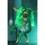 ULTIMATE GRETA GREMLINS 2: THE NEW BATCH. Neca vuelve a presentar la figura Ultimate de Greta, el único Gremlin femenino de la película "Gremlins 2: The New Batch" ("Gremlins 2: La nueva generación" en España). Mide 15 cm e incluye cabello sintético, 1x boa de plumas rosa, 1x poción hormonal y 2x manos intercambiables. Se entrega en una caja con ventana y solapa de apertura.