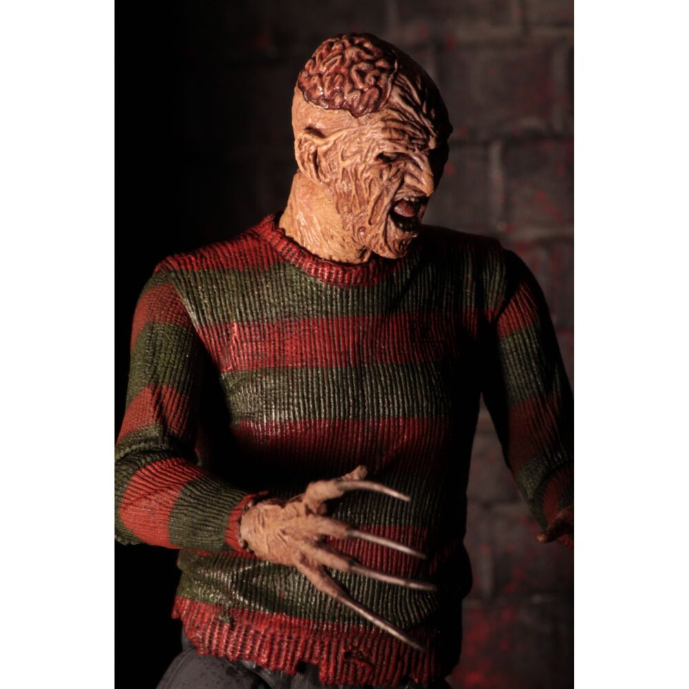 Ultimate freddy krueger a nightmore on elm street part 2. Neca vuelve a añadir a su línea ultimate la figura de freddy krueger basada en la película "a nightmare on elm street part 2: freddy's revenge" ("pesadilla en elm street 2: la venganza de freddy" en españa). Mide 18 cm e incluye 3x cabezas intercambiables, 2x perros demoníacos, 1x mano enguantada, 1x mano afilada, 1x sombrero extraíble y 1x efecto de fuego magnético. Se presenta en una caja con ventana y solapa frontal.