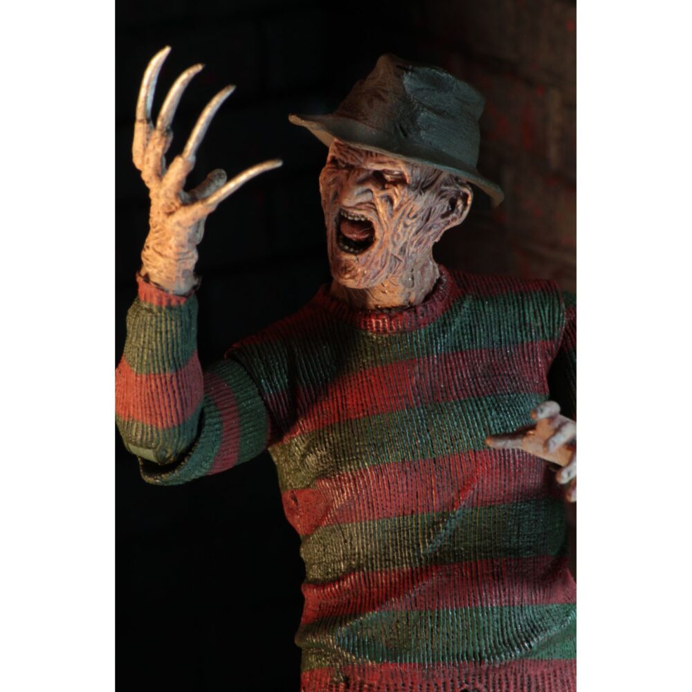 Ultimate freddy krueger a nightmore on elm street part 2. Neca vuelve a añadir a su línea ultimate la figura de freddy krueger basada en la película "a nightmare on elm street part 2: freddy's revenge" ("pesadilla en elm street 2: la venganza de freddy" en españa). Mide 18 cm e incluye 3x cabezas intercambiables, 2x perros demoníacos, 1x mano enguantada, 1x mano afilada, 1x sombrero extraíble y 1x efecto de fuego magnético. Se presenta en una caja con ventana y solapa frontal.