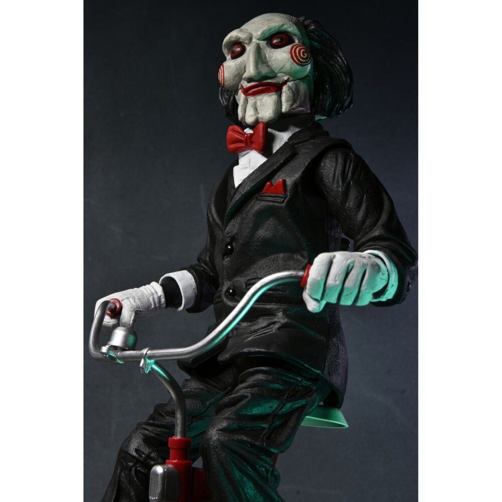 Billy the puppet on tricycle saw 12″. Neca reincorpora en su catálogo esta figura de 30 cm de billy the puppet, el siniestro muñeco de la saga "saw". Se muestra montado en su icónico triciclo rojo con zapatos de purpurina e incluye función de sonido con frases de la película. Emplea 3 baterías de 1. 5v lr44 (incluidas). Se presenta en una caja con ventana.