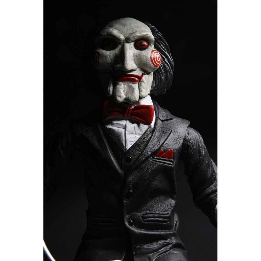 Billy the puppet on tricycle saw 12″. Neca reincorpora en su catálogo esta figura de 30 cm de billy the puppet, el siniestro muñeco de la saga "saw". Se muestra montado en su icónico triciclo rojo con zapatos de purpurina e incluye función de sonido con frases de la película. Emplea 3 baterías de 1. 5v lr44 (incluidas). Se presenta en una caja con ventana.