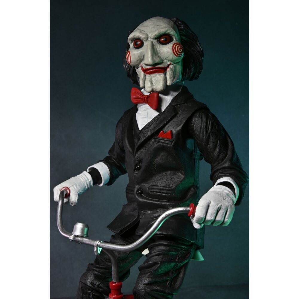 Billy the puppet on tricycle saw 12″. Neca reincorpora en su catálogo esta figura de 30 cm de billy the puppet, el siniestro muñeco de la saga "saw". Se muestra montado en su icónico triciclo rojo con zapatos de purpurina e incluye función de sonido con frases de la película. Emplea 3 baterías de 1. 5v lr44 (incluidas). Se presenta en una caja con ventana.