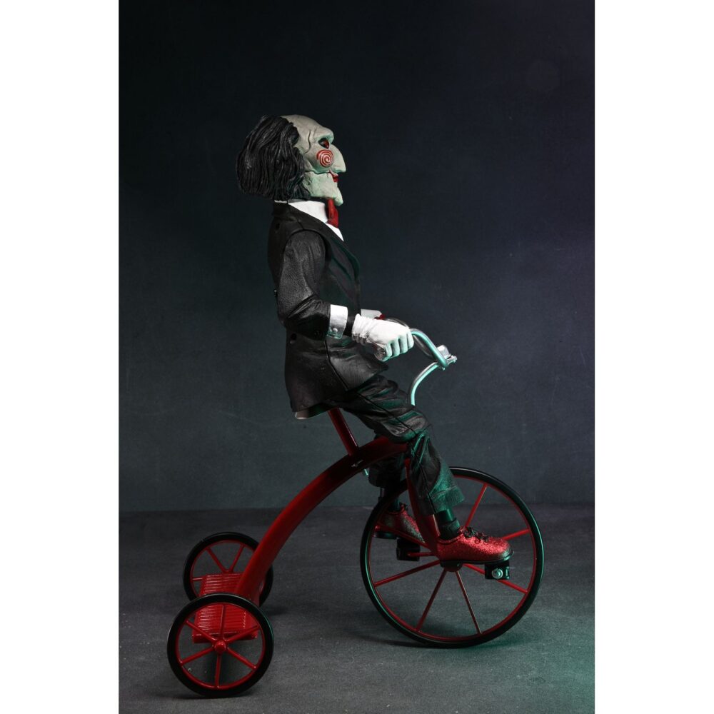 Billy the puppet on tricycle saw 12″. Neca reincorpora en su catálogo esta figura de 30 cm de billy the puppet, el siniestro muñeco de la saga "saw". Se muestra montado en su icónico triciclo rojo con zapatos de purpurina e incluye función de sonido con frases de la película. Emplea 3 baterías de 1. 5v lr44 (incluidas). Se presenta en una caja con ventana.