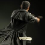 NEO THE MATRIX ART SCALE 1/10. Directamente desde una escena icónica de Matrix, Neo se lanza al aire, con su gabardina ondeando y las armas desenfundadas, desafiando la gravedad y enfrentándose a lo imposible. Esta figura lo captura en pleno salto, congelado en el momento en que las balas vuelan y el tiempo se ralentiza. Es la esencia de Matrix en una sola pose. Como héroe legendario de la trilogía, Neo simboliza la rebelión, la duda y, finalmente, la fe absoluta. Esta escultura lo captura en un momento decisivo: concentrado, en el aire y con el control absoluto. Su gabardina ondeando, sus gafas oscuras y su expresión estoica son un guiño al lenguaje visual que lo convirtió en un icono cinematográfico. La base representa una pared derruida en medio de un tiroteo: agujeros de bala, fragmentos de yeso y cables rotos. Los efectos de polvo esculpidos añaden movimiento dinámico a la escena. El marcado contraste entre su traje negro y los escombros de hormigón realza el dramatismo de la figura. Fabricada en resina y con una altura aproximada de 25 cm a escala 1/10, esta pieza forma parte de la línea Art Scale de Iron Studios, conocida por sus poses cinematográficas y sus detalles realistas. Imprescindible para los fans de Matrix y los coleccionistas de cultura pop que buscan impacto visual.