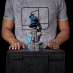 NIGHTWING DC COMIC ART SCALE 1/10.  Captura la acrobacia elegante y el porte seguro de Dick Grayson con un esculpido que define musculatura, paneles del traje y los icónicos bastones escrima. Realizada en polystone con posibles piezas en resina, PVC, metal y tela, luce acabado pintado a mano que aporta profundidad a las texturas y un sombreado nítido en azules y negros. En escala 1/10 y con aprox. 27 cm de altura sobre base, ofrece presencia sólida sin ocupar en exceso, perfecta para coronar una vitrina del universo Batman. Producto oficialmente licenciado, estable y bien equilibrado, pensado para quienes buscan una pieza con calidad tangible, fidelidad al personaje y un look contemporáneo que destaca desde cualquier ángulo.