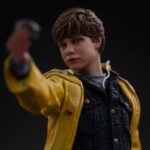 MIKEY WALSH (40TH ANNIVERSARY) THE GOONIES ART SCALE 1/10. Mikey Walsh regresa en esta figura conmemorativa del 40 aniversario de Los Goonies, capturando la energía y la determinación del valiente joven líder. De pie sobre una base con forma de cueva pirata, con un mapa del tesoro en una mano y una moneda de oro en la otra, encarna a la perfección el espíritu de la aventura infantil: misterio, valentía e imaginación. Como líder natural de la pandilla, Mikey puede que no tenga poderes ni equipo, pero lidera con esperanza y lealtad. Su pose, con la mirada puesta en el futuro, refleja ese momento icónico en el que la historia se hace realidad y los niños se convierten en héroes. La moneda que sostiene en la mano conecta el mito con la acción, la esperanza con el descubrimiento. La escultura recrea fielmente su icónico aspecto: impermeable amarillo brillante, camisa vaquera, pantalones vaqueros y zapatillas gastadas. La base está ricamente detallada, con texturas de roca, monedas de oro, reliquias antiguas y una calavera tallada, lo que evoca instantáneamente la atmósfera de la búsqueda subterránea de la película. Fabricada en resina a escala 1/10, la estatua mide aproximadamente 21 cm de altura. Forma parte de la colección Art Scale de Iron Studios, que se centra en la nostalgia y los detalles. Una pieza central perfecta para los fans de Los Goonies, o para cualquiera que todavía crea en los tesoros enterrados y las aventuras con los mejores amigos.