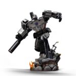 MEGATRON TRANSFORMERS DEMI ART SCALE 1/10. Encarnación de la estrategia despiadada y el poder bruto, Megatron se yergue imponente en esta pose dominante sobre los restos humeantes de sus enemigos. Inspirada en el universo clásico de Transformers, esta figura de resina captura el frío dominio y la presencia icónica del líder Decepticon. Con el cañón de fusión apuntando y listo, la mirada de Megatron se fija en su objetivo con una confianza inquebrantable. Su diseño retrofuturista —chapa metálica cepillada, estructura angular, detalles tecnológicos desgastados— se recrea con una precisión sorprendente. La base representa un campo de batalla en llamas: robots destrozados, cables rotos, llamas esculpidas y efectos de humo realzan la intensidad de la escena. El cañón brillante y aún humeante añade una dramática sensación de acción reciente. Fabricada en resina y con una altura aproximada de 32 cm a escala 1/20, esta estatua pertenece a la línea Demi Art Scale de Iron Studios. Ofrece texturas nítidas, una pose audaz y una base narrativa que realza toda la pieza. Una representación feroz e inolvidable de Megatron, perfecta para los fans que quieren que su exposición irradie amenaza.