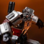 MEGATRON TRANSFORMERS DEMI ART SCALE 1/10. Encarnación de la estrategia despiadada y el poder bruto, Megatron se yergue imponente en esta pose dominante sobre los restos humeantes de sus enemigos. Inspirada en el universo clásico de Transformers, esta figura de resina captura el frío dominio y la presencia icónica del líder Decepticon. Con el cañón de fusión apuntando y listo, la mirada de Megatron se fija en su objetivo con una confianza inquebrantable. Su diseño retrofuturista —chapa metálica cepillada, estructura angular, detalles tecnológicos desgastados— se recrea con una precisión sorprendente. La base representa un campo de batalla en llamas: robots destrozados, cables rotos, llamas esculpidas y efectos de humo realzan la intensidad de la escena. El cañón brillante y aún humeante añade una dramática sensación de acción reciente. Fabricada en resina y con una altura aproximada de 32 cm a escala 1/20, esta estatua pertenece a la línea Demi Art Scale de Iron Studios. Ofrece texturas nítidas, una pose audaz y una base narrativa que realza toda la pieza. Una representación feroz e inolvidable de Megatron, perfecta para los fans que quieren que su exposición irradie amenaza.