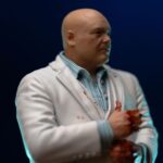 KINGPIN DAREDEVIL: BORN AGAIN ART SCALE 1/10. En el oscuro y urbano universo de Marvel, Wilson Fisk, alias Kingpin, reina sobre el crimen organizado con una inteligencia fría y mano de hierro. Enemigo emblemático de Daredevil, encarna la corrupción arraigada en las calles de Hell's Kitchen, utilizando su influencia política y su fuerza bruta para afianzar su poder. Aquí representado de pie en una postura imponente, Kingpin sujeta su bastón con calma y seguridad. Su mirada dura y su estatura imponente transmiten una autoridad indiscutible. Su atuendo, un traje blanco perfectamente cortado, contrasta con la atmósfera amenazante que lo rodea, lo que subraya su gusto por el control y la puesta en escena. Cada detalle visual está cuidadosamente trabajado: cabeza rapada, rasgos cerrados, camisa azul pálida y bastón esculpido. La base imita un adoquín urbano roto, acentuando el contraste entre su aparente elegancia y la brutalidad de su entorno. El realismo de los pliegues de la tela y la textura de la base aportan profundidad y presencia a esta pieza. Fabricada en resina, esta figura mide aproximadamente 21 cm y está diseñada a escala 1/10. Forma parte de la colección Art Scale de Iron Studios y se apoya en una base detallada, lista para completar una escena realista de Marvel o para presidir por sí sola como representación de uno de los antagonistas más poderosos del universo.