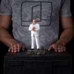KINGPIN DAREDEVIL: BORN AGAIN ART SCALE 1/10. En el oscuro y urbano universo de Marvel, Wilson Fisk, alias Kingpin, reina sobre el crimen organizado con una inteligencia fría y mano de hierro. Enemigo emblemático de Daredevil, encarna la corrupción arraigada en las calles de Hell's Kitchen, utilizando su influencia política y su fuerza bruta para afianzar su poder. Aquí representado de pie en una postura imponente, Kingpin sujeta su bastón con calma y seguridad. Su mirada dura y su estatura imponente transmiten una autoridad indiscutible. Su atuendo, un traje blanco perfectamente cortado, contrasta con la atmósfera amenazante que lo rodea, lo que subraya su gusto por el control y la puesta en escena. Cada detalle visual está cuidadosamente trabajado: cabeza rapada, rasgos cerrados, camisa azul pálida y bastón esculpido. La base imita un adoquín urbano roto, acentuando el contraste entre su aparente elegancia y la brutalidad de su entorno. El realismo de los pliegues de la tela y la textura de la base aportan profundidad y presencia a esta pieza. Fabricada en resina, esta figura mide aproximadamente 21 cm y está diseñada a escala 1/10. Forma parte de la colección Art Scale de Iron Studios y se apoya en una base detallada, lista para completar una escena realista de Marvel o para presidir por sí sola como representación de uno de los antagonistas más poderosos del universo.