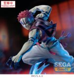 AKAZA DEMON SLAYER: KIMETSU NO YAIBA ESTATUA PVC XROSS LINK ANIME. Miembro de los Doce Kizuki y villano destacado del arco argumental del Tren Mugen, Akaza encarna la brutalidad elegante y el poderío marcial. Esta figura lo captura en un momento de movimiento congelado, tenso, enroscado y listo para atacar, en equilibrio sobre una base que amplifica la fuerza explosiva de su ataque. Akaza aparece en plena acción, con el torso girado, el brazo levantado y la pierna extendida, como si estuviera lanzando un golpe devastador. Su intensa expresión y sus icónicas marcas faciales enfatizan su precisión y su poder letal. Las cintas que cuelgan de su cinturón añaden una sensación de velocidad y movimiento a la escultura. Su diseño recrea fielmente el estilo del anime: torso desnudo con marcas demoníacas azules, pelo rosa puntiagudo, pantalones blancos anchos y detalles en rojo. La base, hecha de PVC azul translúcido, se asemeja a una explosión de energía estilizada o a una ola de agua, lo que añade impacto visual y movimiento a la exposición. Con una altura aproximada de 14 cm, esta figura de PVC forma parte de la colección Xross Link de SEGA. Con una pose dinámica, una base de efectos impresionante y detalles nítidos, es perfecta para capturar la intensidad de la batalla en tu estantería o ampliar tu colección de Demon Slayer.