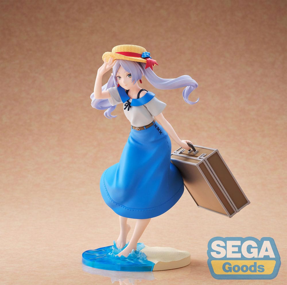 Frieren summer dress frieren: beyond journey's end estatua luminasta pvc. Frieren, la antigua maga élfica, aparece aquí en una rara versión veraniega que se aleja de sus habituales viajes mágicos. Procedente de frieren: beyond journey’s end, esta figura captura un momento sereno y nostálgico, libre de misiones heroicas, envuelto en calidez y tranquila reflexión. Se la ve sujetando suavemente su sombrero de paja con una mano para protegerlo de la brisa, mientras con la otra tira de una maleta vintage. Su mirada suave y distante y el sutil movimiento de su vestido y su cabello evocan un fotograma de un día fugaz y tranquilo. Su atuendo consiste en un vestido azul de verano de estilo marinero, adornado con sutiles bordados y un sombrero de ala ancha a juego decorado con lazos rojos y azules. De pie, descalza en el agua, frieren posa sobre una base escénica que combina olas translúcidas y una costa arenosa, ilustrando a la perfección una pausa tranquila entre viajes. Con una altura de unos 20 cm, esta figura de pvc de la línea luminasta de sega ofrece una atmósfera tranquila, un acabado limpio y una escultura elegante. Es una tierna representación del personaje, ideal para coleccionistas atraídos por figuras expresivas y emocionalmente ricas.