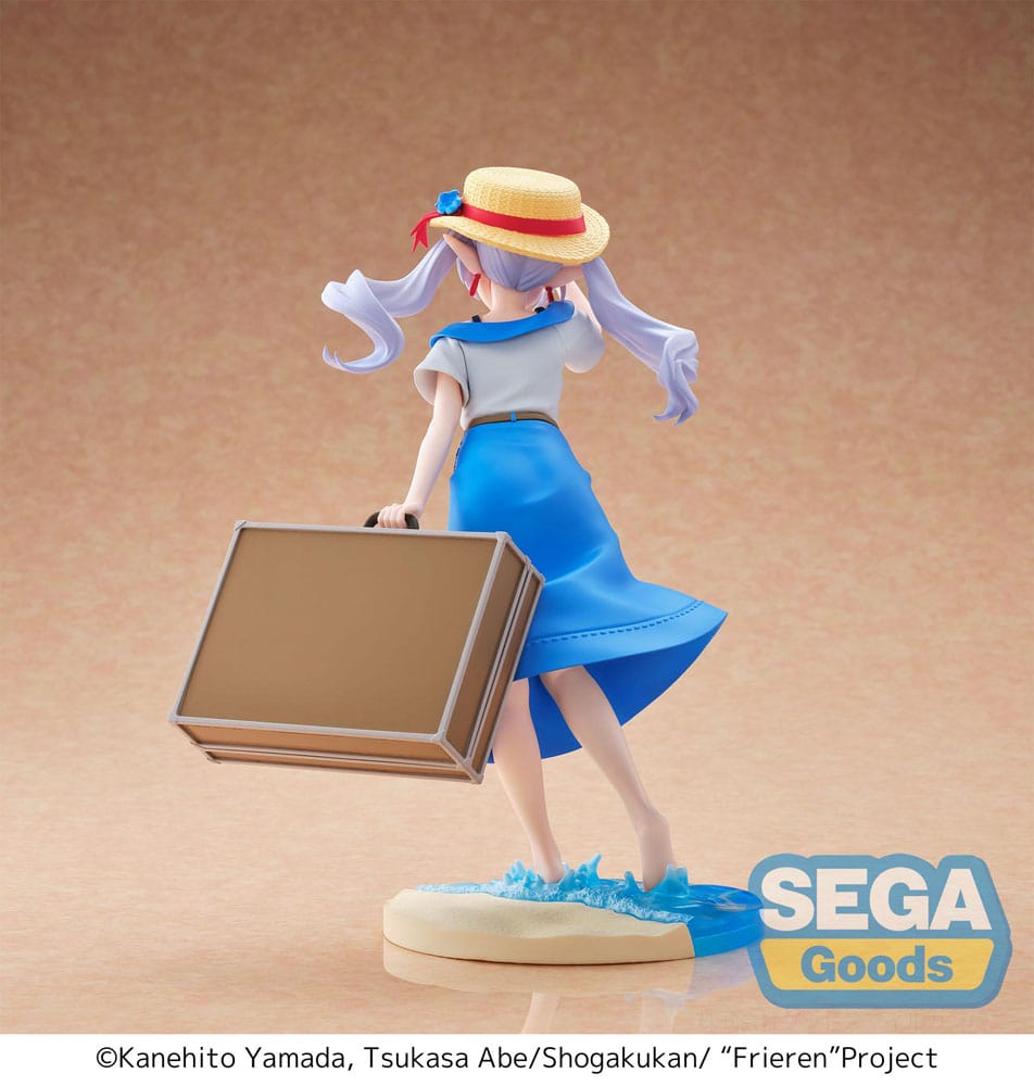 Frieren summer dress frieren: beyond journey's end estatua luminasta pvc. Frieren, la antigua maga élfica, aparece aquí en una rara versión veraniega que se aleja de sus habituales viajes mágicos. Procedente de frieren: beyond journey’s end, esta figura captura un momento sereno y nostálgico, libre de misiones heroicas, envuelto en calidez y tranquila reflexión. Se la ve sujetando suavemente su sombrero de paja con una mano para protegerlo de la brisa, mientras con la otra tira de una maleta vintage. Su mirada suave y distante y el sutil movimiento de su vestido y su cabello evocan un fotograma de un día fugaz y tranquilo. Su atuendo consiste en un vestido azul de verano de estilo marinero, adornado con sutiles bordados y un sombrero de ala ancha a juego decorado con lazos rojos y azules. De pie, descalza en el agua, frieren posa sobre una base escénica que combina olas translúcidas y una costa arenosa, ilustrando a la perfección una pausa tranquila entre viajes. Con una altura de unos 20 cm, esta figura de pvc de la línea luminasta de sega ofrece una atmósfera tranquila, un acabado limpio y una escultura elegante. Es una tierna representación del personaje, ideal para coleccionistas atraídos por figuras expresivas y emocionalmente ricas.