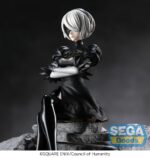2B NIER:AUTOMATA VER1.1A ESTATUA PVC PM PERCHING. En el sombrío y melancólico mundo de NieR:Automata, 2B es una androide de combate creada para proteger a la humanidad en una guerra desesperada contra máquinas alienígenas. Estoica, disciplinada y a menudo silenciosa, representa una fría elegancia dedicada a una misión trágica. Esta figura de la colección PM Perching captura a 2B en un momento de tensa calma. Sentada con los brazos cruzados y las piernas elegantemente dobladas, mantiene la compostura y la distancia emocional. Su postura sugiere una vigilancia silenciosa, congelada en una rara pausa entre batallas. Su diseño se reproduce fielmente: vestido negro de mangas abullonadas con sutiles detalles de encaje en el cuello y el dobladillo, guantes blancos, botas altas y su icónica visera. Su corto cabello plateado enmarca su rostro parcialmente oculto. La escultura captura cada pliegue y textura con sobriedad y precisión. Con una altura aproximada de 13 cm, esta figura de PVC está diseñada para posarse en un borde o superficie plana. Con líneas limpias, una pose minimalista y un acabado nítido, transmite el misterio y el control de 2B, incluso en la quietud.