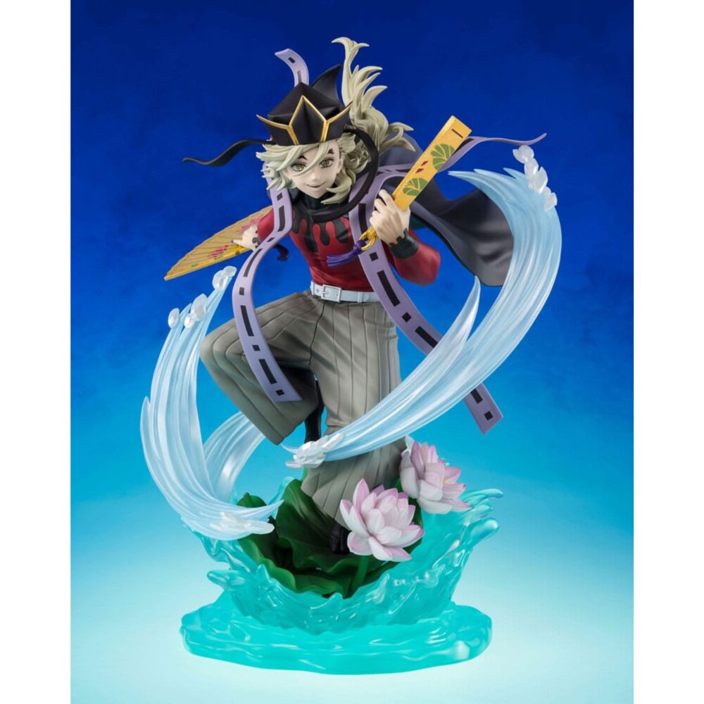 DOMA DEMON SLAYER: KIMETSU NO YAIBA FIGUARTS ZERO. En el brutal y místico universo de Demon Slayer: Kimetsu no Yaiba, Dôma destaca como una de las Doce Lunas Demoníacas más aterradoras, combinando elegancia, crueldad y fanatismo. Esta figura FiguartsZERO inmortaliza al demonio de rango superior Dos en una escena dinámica y escalofriante, fiel a su inquietante personalidad y a sus técnicas visualmente espectaculares. En plena invocación de sus técnicas de hielo, Dôma adopta una postura aérea y amenazante, con los brazos extendidos, blandiendo dos abanicos dorados decorados con motivos florales. Viste su icónico traje: una camiseta roja ajustada, mangas largas, pantalones holgados grises y una capa negra con bordes violetas en forma de cinta. Su sombrero triangular negro se mantiene firmemente sobre su cabello rubio, recogido en mechones revoloteantes. La base esculpida representa un efecto de hielo estilizado, que se eleva en remolinos translúcidos alrededor de su cuerpo, acentuado por flores de loto en plena floración. El efecto da la impresión de que Dôma baila sobre el agua, listo para lanzar un ataque mortal. El movimiento general de la escena es fluido, casi coreografiado, lo que refleja su naturaleza refinada y letal a la vez. Con una altura de 23 cm, esta figura de PVC impresiona por la delicadeza de sus detalles: texturas de tela, reflejos nacarados en los abanicos, transparencia trabajada en los elementos de hielo. La base es a la vez decorativa y funcional, lo que refuerza el impacto visual de la pose sin afectar a la estabilidad. Una pieza de colección memorable para los fans de la estética siniestra y estilizada de Demon Slayer.