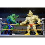 STUMP WRESTLING ACE DUCK TEENAGE MUTANT NINJA TURTLES ARCHIE COMICS. Ace Duck, personaje secundario de culto del universo Tortugas Ninja, reaparece aquí en su versión Stump Wrestling, inspirada en los famosos combates intergalácticos del multiverso TMNT. Este carismático luchador antropomórfico adopta aquí el aspecto de un guerrero samurái, listo para luchar en la arena con estilo y poderío. La figura representa a Ace Duck con un atuendo inspirado en el Japón feudal, con un kimono azul y negro, un cinturón rojo atado a la cintura y una espada enfundada. Su complexión robusta está perfectamente representada, con brazos musculosos, patas palmeadas y un feroz rostro de pato con colmillos visibles. Todo ello se acentúa con una capa de tela marrón y una variedad de accesorios evocadores. El conjunto incluye varias manos intercambiables, una antorcha esculpida, un escudo redondo y una gran capa flexible para variar las poses. Los detalles están cuidados al máximo: nervaduras en las alas, texturas del kimono, funda realista. La articulación fluida permite colocarlo en poses de combate o de parada. Con sus 18 cm, esta figura de NECA combina un guiño retro con una ejecución moderna. Una pieza ideal para los coleccionistas de la gama TMNT que quieran enriquecer su exposición con variantes originales y cuidadas.