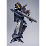 VF-17S NIGHTMARE STEALTH VALKYRIE GAMLIN KIZAKI MACROSS 7 DX COGOKIN. En el universo de Macross 7, el VF-17S Nightmare Stealthvalkyrie es un caza de combate altamente sofisticado, pilotado por Gamlin Kizaki, miembro de la élite Sound Force. Diseñado para misiones de alto riesgo, este modelo furtivo destaca por su robustez, su tecnología punta y su aspecto amenazador. Esta figura impresiona a primera vista con su diseño anguloso y su aspecto militarizado. El color oscuro, predominantemente azul noche, se realza con toques amarillos y rojos, fieles al diseño original. El rostro del mecha, de aspecto casi humanoide, añade una dimensión intimidante a su silueta. El VF-17S se presenta de pie, con un rifle de asalto en la mano y las piernas ancladas al suelo en una postura lista para la acción. Cada panel, articulación e inscripción visible se reproduce con precisión. Los acabados metálicos añaden profundidad, y la textura de las superficies alterna entre mate y brillante según las zonas del cuerpo. Con una altura aproximada de 25 cm, esta figura de metal forma parte de la gama DX Chogokin de Bandai. Ofrece numerosas opciones de posado y un realismo mecánico que hará las delicias de los fans del mecha y de Macross.