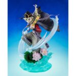DOMA DEMON SLAYER: KIMETSU NO YAIBA FIGUARTS ZERO. En el brutal y místico universo de Demon Slayer: Kimetsu no Yaiba, Dôma destaca como una de las Doce Lunas Demoníacas más aterradoras, combinando elegancia, crueldad y fanatismo. Esta figura FiguartsZERO inmortaliza al demonio de rango superior Dos en una escena dinámica y escalofriante, fiel a su inquietante personalidad y a sus técnicas visualmente espectaculares. En plena invocación de sus técnicas de hielo, Dôma adopta una postura aérea y amenazante, con los brazos extendidos, blandiendo dos abanicos dorados decorados con motivos florales. Viste su icónico traje: una camiseta roja ajustada, mangas largas, pantalones holgados grises y una capa negra con bordes violetas en forma de cinta. Su sombrero triangular negro se mantiene firmemente sobre su cabello rubio, recogido en mechones revoloteantes. La base esculpida representa un efecto de hielo estilizado, que se eleva en remolinos translúcidos alrededor de su cuerpo, acentuado por flores de loto en plena floración. El efecto da la impresión de que Dôma baila sobre el agua, listo para lanzar un ataque mortal. El movimiento general de la escena es fluido, casi coreografiado, lo que refleja su naturaleza refinada y letal a la vez. Con una altura de 23 cm, esta figura de PVC impresiona por la delicadeza de sus detalles: texturas de tela, reflejos nacarados en los abanicos, transparencia trabajada en los elementos de hielo. La base es a la vez decorativa y funcional, lo que refuerza el impacto visual de la pose sin afectar a la estabilidad. Una pieza de colección memorable para los fans de la estética siniestra y estilizada de Demon Slayer.