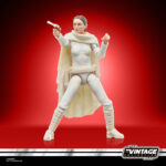 PADME AMIDALA VINTAGE COLLECTION STAR WARS ATTACK OF THE CLONES. Hasbro presenta en a su línea The Vintage Collection la figura de Padmé Amidala, inspirada en la apariencia de su personaje en la película "Star Wars: Attack of the Clones" ("Star Wars: El ataque de los clones" en España). Mide 9,5 cm, cuenta con un esculpido fiel al personaje y múltiples puntos de articulación. Incluye 1x capa removible, 1x bláster corto y 1x bláster largo. Su embalaje tipo blíster reproduce el estilo clásico de Kenner, con logotipo vintage y numeración para coleccionistas. UNIDADES LIMITADAS.