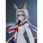 OGURI CAP UMA MUSUME PRETTY DERBY ESTATUA PVC 1/7. En el mundo de Uma Musume Pretty Derby, Oguri Cap es una de las competidoras más emblemáticas, inspirada en un legendario caballo de carreras real. Tanto en el juego como en la franquicia, encarna la determinación y la elegancia, con una presencia imponente que deja huella tanto en sus rivales como en sus fans. Su papel destaca como una luchadora orgullosa y segura de sí misma, siempre dispuesta a afrontar retos en la pista de carreras. Fiel a su modelo histórico, Oguri Cap se distingue por su aplomo inquebrantable y un temperamento que inspira respeto y admiración. Esta figura captura su carisma: Oguri Cap aparece con un uniforme blanco con detalles azules y dorados, complementado con un pañuelo rojo que fluye ligeramente hacia un lado. Su larga melena plateada, adornada con una diadema con motivos de estrellas y sus orejas de caballo, cae suavemente por su espalda. La falda plisada oscura, las medias y las botas blancas enfatizan su estilo atlético y elegante. Con el puño cerrado y la mirada decidida, su pose refleja perfectamente su espíritu luchador. Fabricada en PVC a escala 1/7, la figura mide unos 25 centímetros de altura. Se pueden apreciar los finos detalles en los pliegues de su traje, los mechones de su cabello y los toques metálicos de sus accesorios. La base circular con degradados azules y morados realza su presencia dinámica y resalta su imponente silueta.