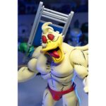 STUMP WRESTLING ACE DUCK TEENAGE MUTANT NINJA TURTLES ARCHIE COMICS. Ace Duck, personaje secundario de culto del universo Tortugas Ninja, reaparece aquí en su versión Stump Wrestling, inspirada en los famosos combates intergalácticos del multiverso TMNT. Este carismático luchador antropomórfico adopta aquí el aspecto de un guerrero samurái, listo para luchar en la arena con estilo y poderío. La figura representa a Ace Duck con un atuendo inspirado en el Japón feudal, con un kimono azul y negro, un cinturón rojo atado a la cintura y una espada enfundada. Su complexión robusta está perfectamente representada, con brazos musculosos, patas palmeadas y un feroz rostro de pato con colmillos visibles. Todo ello se acentúa con una capa de tela marrón y una variedad de accesorios evocadores. El conjunto incluye varias manos intercambiables, una antorcha esculpida, un escudo redondo y una gran capa flexible para variar las poses. Los detalles están cuidados al máximo: nervaduras en las alas, texturas del kimono, funda realista. La articulación fluida permite colocarlo en poses de combate o de parada. Con sus 18 cm, esta figura de NECA combina un guiño retro con una ejecución moderna. Una pieza ideal para los coleccionistas de la gama TMNT que quieran enriquecer su exposición con variantes originales y cuidadas.