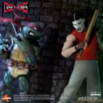 CASEY JONES TEENAGE MUTANT NINJA TURTLES ONE: 12 COLLECTIVE. Mezco Toyz presenta dentro de su línea One:12 Collective la figura articulada de Casey Jones, inspirada en la apariencia del personaje del universo "Teenage Mutant Ninja Turtles". Esta figura tiene una altura aproximada de 17 cm, cuenta con más de 32 puntos de articulación y tiene un montón de detalles pintados a mano. Viene acompañada de 3x placas faciales, 10x manos adicionales y 1x bolsa de golf para transportar su arsenal improvisado compuesto por: 1x bate de cricket, 3x sticks de hockey (uno de ellos de portero), 2x palos de golf y 4x bates de béisbol (uno de ellos roto). Su atuendo incluye 1x camiseta de punto roja sin mangas, 1x pantalón de chándal, 1x par de zapatillas deportivas, 1x protector de hombros y 1x sudadera blanca con capucha. También incluye una base circular con logo y un brazo articulado. Se presenta en una caja ilustrada.