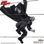 MARV SIN CITY ONE:12 COLLECTIVE. Mezco Toyz presenta dentro de su línea One:12 Collective la figura articulada de Marv, inspirada en la apariencia del personaje de la icónica obra de Frank Miller "Sin City". Esta imponente figura tiene una altura aproximada de 17 cm y refleja a la perfección el estilo crudo y violento del antihéroe más brutal de Basin City. Cuenta con más de 30 puntos de articulación y viene acompañada de 3x placas faciales, 9x manos adicionales, 1x pistola Gladys con 2x cargadores extraíbles, 2x efectos de disparo, 1x sierra, 1x hacha, 1x bidón de gasolina con 1x efecto de llama extraíble, 1x mechero encendido, 1x paquete de cigarrillos abierto, 3x cigarrillos encendidos, 1x par de esposas y 1x cabeza decapitada de Kevin con mechón desmontable que permite sujetarla. Su atuendo incluye un abrigo largo envejecido, camiseta, pantalones, botas y un colgante con cruz. Se presenta en una caja con detalles gráficos inspirados en la obra original.
