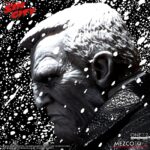 MARV SIN CITY ONE:12 COLLECTIVE. Mezco Toyz presenta dentro de su línea One:12 Collective la figura articulada de Marv, inspirada en la apariencia del personaje de la icónica obra de Frank Miller "Sin City". Esta imponente figura tiene una altura aproximada de 17 cm y refleja a la perfección el estilo crudo y violento del antihéroe más brutal de Basin City. Cuenta con más de 30 puntos de articulación y viene acompañada de 3x placas faciales, 9x manos adicionales, 1x pistola Gladys con 2x cargadores extraíbles, 2x efectos de disparo, 1x sierra, 1x hacha, 1x bidón de gasolina con 1x efecto de llama extraíble, 1x mechero encendido, 1x paquete de cigarrillos abierto, 3x cigarrillos encendidos, 1x par de esposas y 1x cabeza decapitada de Kevin con mechón desmontable que permite sujetarla. Su atuendo incluye un abrigo largo envejecido, camiseta, pantalones, botas y un colgante con cruz. Se presenta en una caja con detalles gráficos inspirados en la obra original.