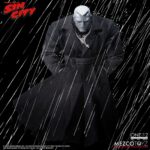 MARV SIN CITY ONE:12 COLLECTIVE. Mezco Toyz presenta dentro de su línea One:12 Collective la figura articulada de Marv, inspirada en la apariencia del personaje de la icónica obra de Frank Miller "Sin City". Esta imponente figura tiene una altura aproximada de 17 cm y refleja a la perfección el estilo crudo y violento del antihéroe más brutal de Basin City. Cuenta con más de 30 puntos de articulación y viene acompañada de 3x placas faciales, 9x manos adicionales, 1x pistola Gladys con 2x cargadores extraíbles, 2x efectos de disparo, 1x sierra, 1x hacha, 1x bidón de gasolina con 1x efecto de llama extraíble, 1x mechero encendido, 1x paquete de cigarrillos abierto, 3x cigarrillos encendidos, 1x par de esposas y 1x cabeza decapitada de Kevin con mechón desmontable que permite sujetarla. Su atuendo incluye un abrigo largo envejecido, camiseta, pantalones, botas y un colgante con cruz. Se presenta en una caja con detalles gráficos inspirados en la obra original.