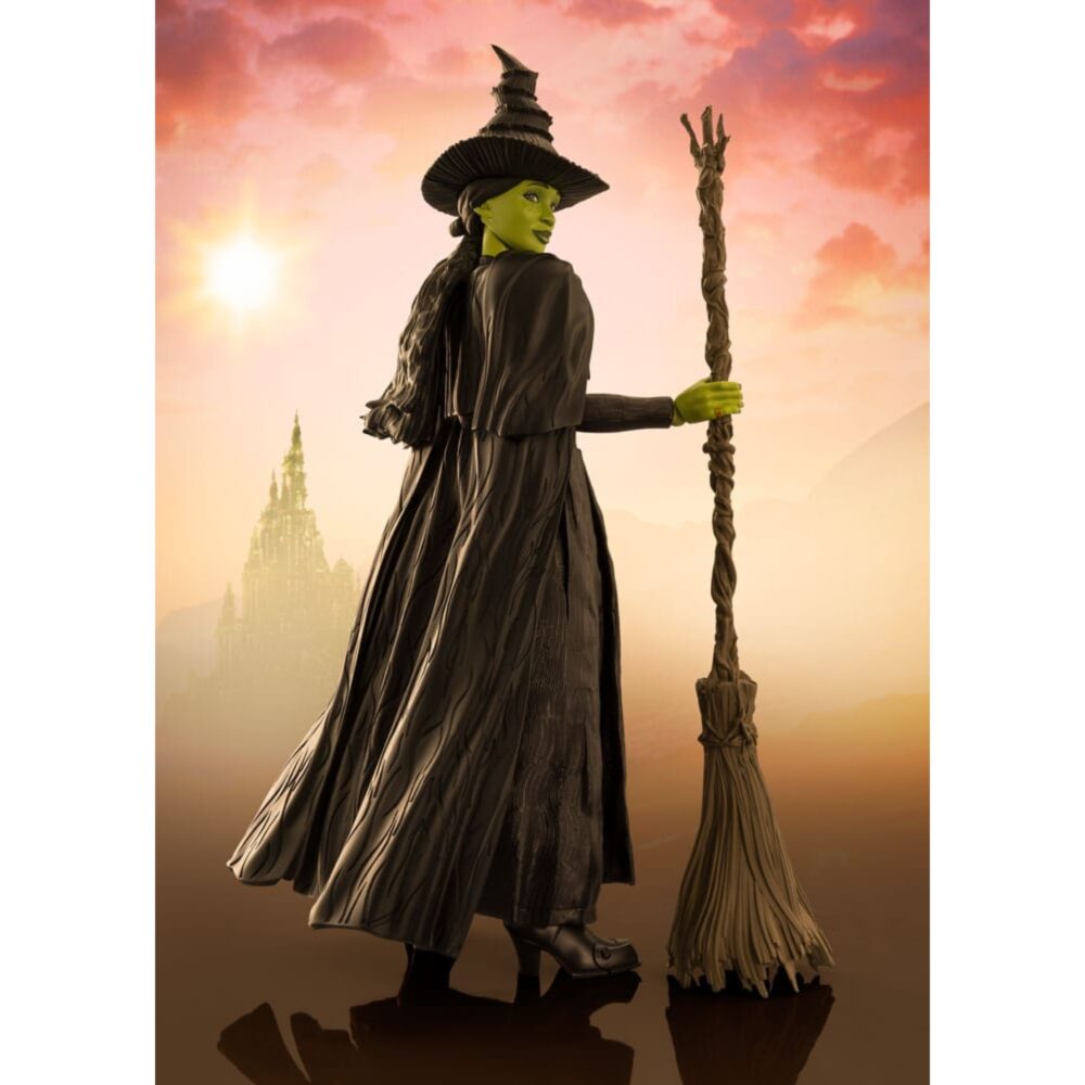 ELPHABA WICKED SH FIGUARTS. Inspirada en el musical de culto Wicked, esta figura captura toda la misteriosa intensidad de Elphaba, la bruja con un destino adverso. En un mundo en el que la apariencia y la verdad se enfrentan, ella se enfrenta con orgullo a los prejuicios y las manipulaciones, barriendo las convenciones con un simple hechizo. Heroína atípica y conmovedora, Elphaba encarna una resistencia interior marcada por la injusticia. Lejos de la imagen tradicional de la bruja malvada, a lo largo de la historia revela una complejidad poco común y conmovedora, lo que la convierte en uno de los personajes más fuertes y humanos de la narración. La figura la muestra de espaldas, en una postura llena de dignidad, ligeramente girada, con una escoba en la mano. Su piel verde resalta bajo la luz del atardecer, contrastando con su largo vestido negro texturizado, su sombrero puntiagudo torcido y su cabello trenzado. Cada pliegue de la tela, cada detalle del accesorio evoca un trabajo minucioso fiel al universo de la escena. Con unos 14 cm de altura, esta figura articulada de PVC pertenece a la colección S.H. Figuarts de Bandai. La delicada escultura, los efectos de textura del vestido, el realismo de la escoba y las elegantes proporciones la convierten en una pieza expresiva, perfecta para recrear escenas emblemáticas del musical.