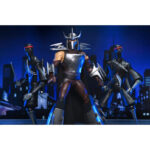 ULTIMATE SHREDDER TEENAGE MUTANT NINJA TURTLES (2012). En la serie animada Teenage Mutant Ninja Turtles de 2012, Shredder es el enemigo más formidable de las Tortugas Ninja. Su presencia eleva instantáneamente el nivel de tensión. Calculador, despiadado e impulsado por la venganza, marca la tensión de la serie cada vez que aparece en escena. A lo largo de la serie, Shredder actúa como un estratega implacable cuyo objetivo es destruir a Splinter y a sus alumnos. Su obsesión alimenta algunas de las batallas más intensas de la serie. A través de la manipulación, los duelos brutales y las alianzas inestables, sigue siendo una fuerza imparable. La figura captura con precisión su aspecto de 2012: armadura angular plateada, guanteletes con largas espadas, grebas pesadas y un casco con cuernos afilados. Una capa negra realza su imponente silueta. Los accesorios incluyen múltiples espadas intercambiables, manos adicionales, una cabeza alternativa sin máscara y una criatura Krang rosa sacada directamente de los dibujos animados. Los detalles nítidos resaltan la armadura metálica, el esculpido limpio, las articulaciones discretas y los accesorios a escala. Con 18 cm de altura, la figura ofrece una articulación sólida, perfecta para recrear los momentos icónicos de Shredder.