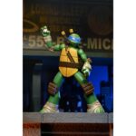 ULTIMATE LEONARDO TEENAGE MUTANT NINJA TURTLES (2012). En la serie animada Teenage Mutant Ninja Turtles de 2012, Leonardo encarna la figura del líder tranquilo y decidido. Siempre preocupado por hacer lo correcto, guía a sus hermanos con una mezcla de responsabilidad, disciplina y dudas que poco a poco aprende a superar. Su trayectoria muestra a un luchador que se esfuerza por progresar tanto en su técnica como en su papel de líder. Entre decisiones difíciles, entrenamientos intensos y momentos más ligeros con su equipo, Leo sigue siendo el punto de equilibrio que mantiene unido al grupo. La figura reproduce con precisión su diseño de 2012: caparazón beige y marrón, piel verde, máscara azul y protecciones marrones en las extremidades. Su expresión neutra puede sustituirse por una cabeza alternativa más dinámica. Los accesorios incluyen sus dos katanas, manos intercambiables, una porción de pizza, un trozo de armadura y un bláster fiel al estilo de la serie. Los detalles son nítidos: segmentos esculpidos del caparazón, pintura limpia, articulaciones bien integradas y accesorios correctamente proporcionados. Con sus 18 cm, la figura permite numerosas poses emblemáticas del personaje.