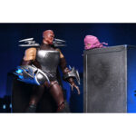 ULTIMATE SHREDDER TEENAGE MUTANT NINJA TURTLES (2012). En la serie animada Teenage Mutant Ninja Turtles de 2012, Shredder es el enemigo más formidable de las Tortugas Ninja. Su presencia eleva instantáneamente el nivel de tensión. Calculador, despiadado e impulsado por la venganza, marca la tensión de la serie cada vez que aparece en escena. A lo largo de la serie, Shredder actúa como un estratega implacable cuyo objetivo es destruir a Splinter y a sus alumnos. Su obsesión alimenta algunas de las batallas más intensas de la serie. A través de la manipulación, los duelos brutales y las alianzas inestables, sigue siendo una fuerza imparable. La figura captura con precisión su aspecto de 2012: armadura angular plateada, guanteletes con largas espadas, grebas pesadas y un casco con cuernos afilados. Una capa negra realza su imponente silueta. Los accesorios incluyen múltiples espadas intercambiables, manos adicionales, una cabeza alternativa sin máscara y una criatura Krang rosa sacada directamente de los dibujos animados. Los detalles nítidos resaltan la armadura metálica, el esculpido limpio, las articulaciones discretas y los accesorios a escala. Con 18 cm de altura, la figura ofrece una articulación sólida, perfecta para recrear los momentos icónicos de Shredder.